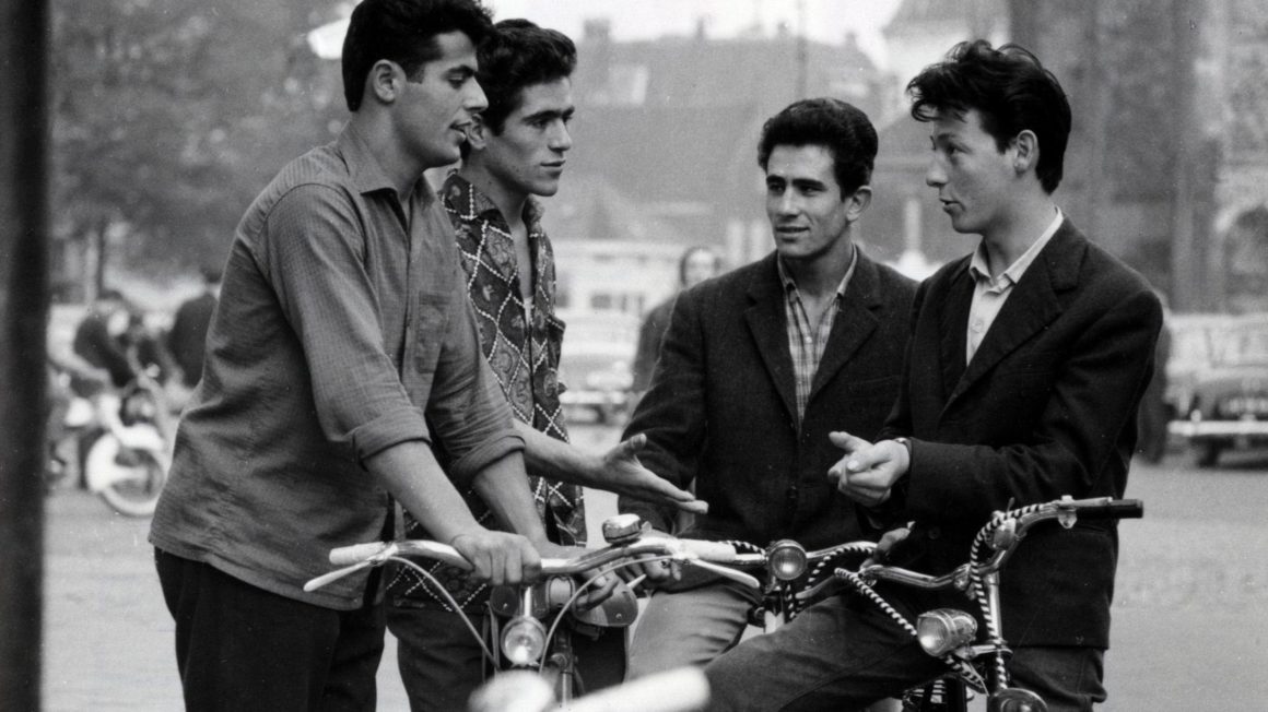 Vier jonge gastarbeiders met fietsen in Enschede, 1969.