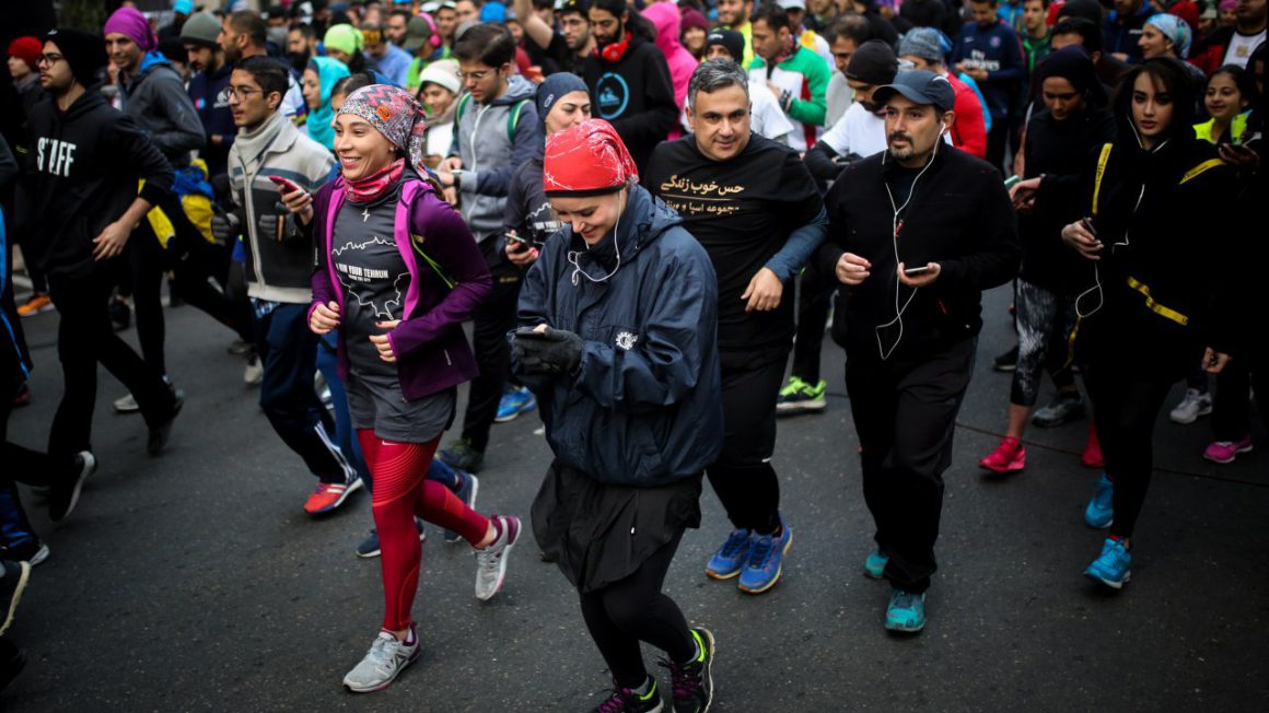 Mannen en vrouwen lopen samen op vrijdagochtend in Teheran