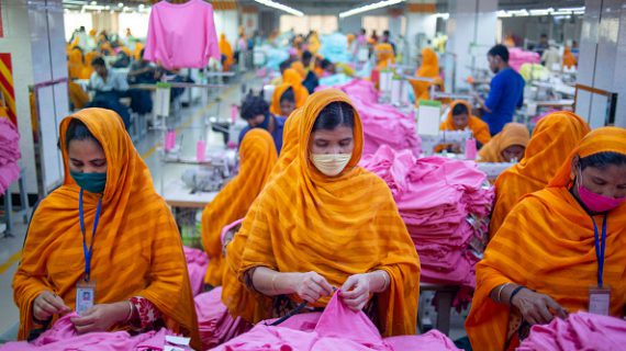 Garments workers are seen working in a sewing and finishing