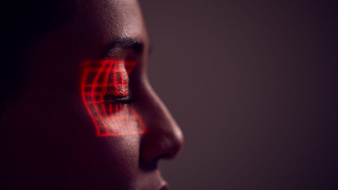 Facial Recognition Technology Concept As Woman Has Red Grid Projected Onto Eye In Studio