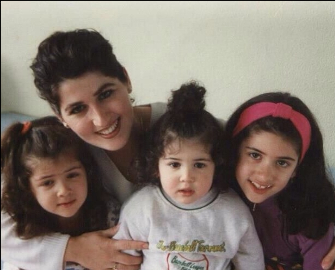 Een vrolijk portret van Kosovare, vooraan in het midden, met haar twee oudere zussen en haar moeder in het azc in 1997.