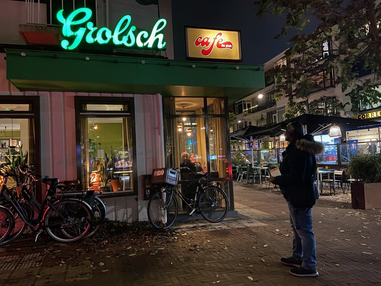 Yadir met zijn registratiekaart in zijn linkerhand kijkt naar café de Plak in Nijmegen.