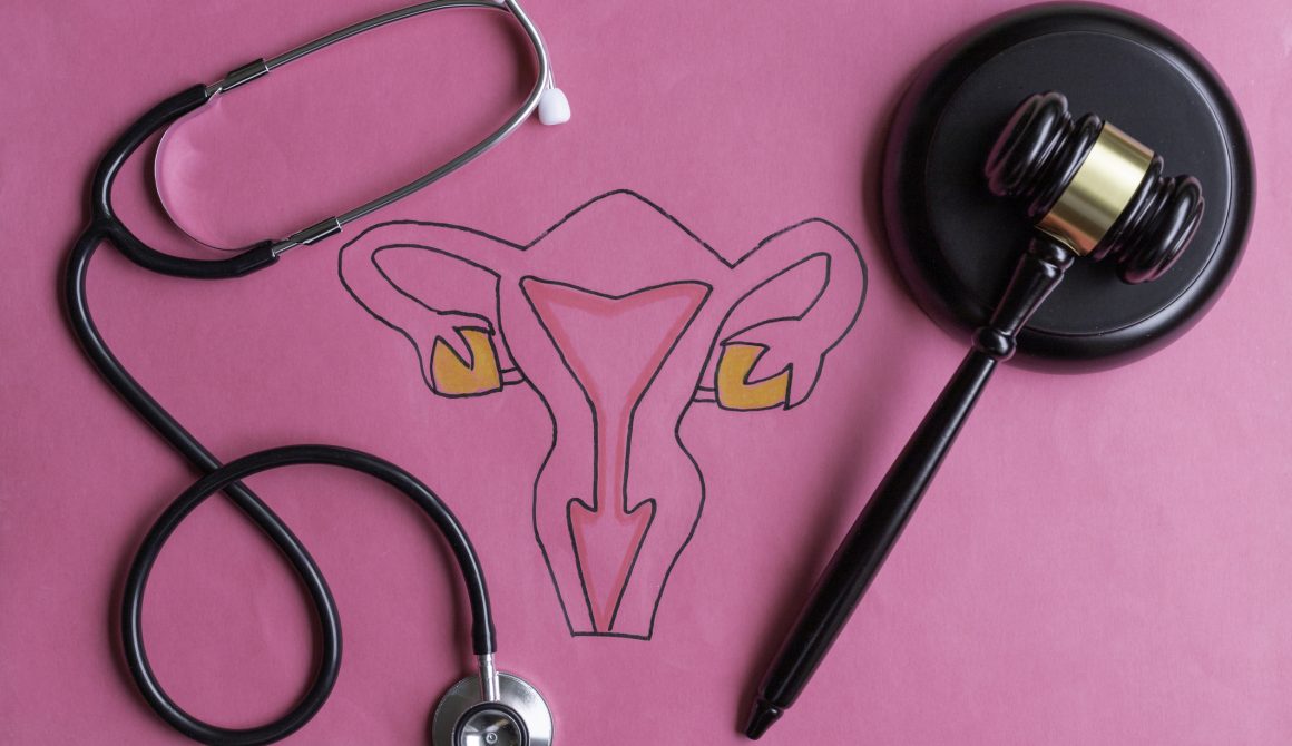 Drawing of female reproductive system with judge’s gavel and stethoscope